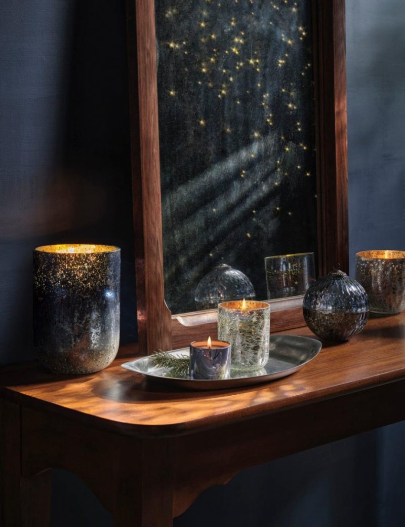 Świeca premium ILLUME North Sky zapalona we wnętrzu salonu