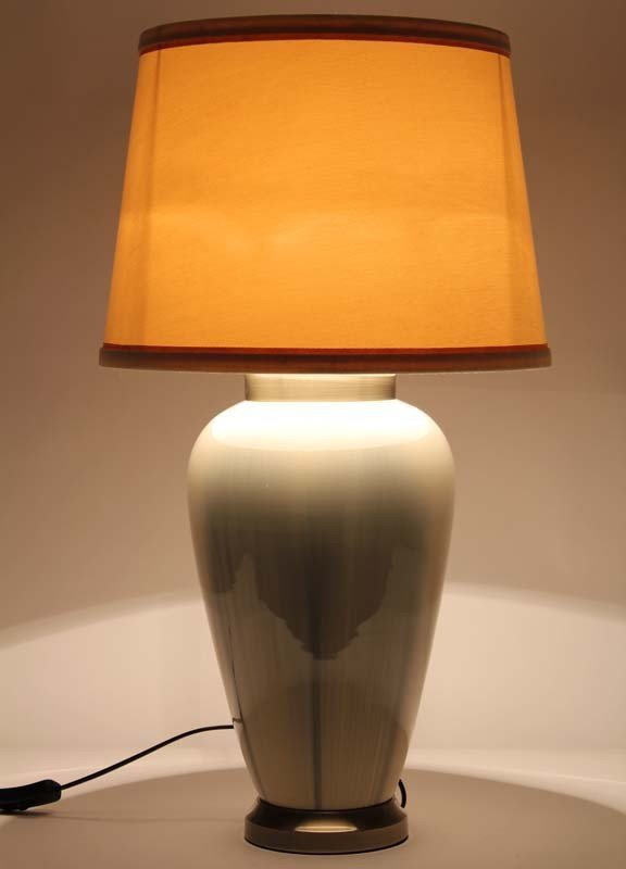 Kremowa lampa z abażurem i złotym wykończeniem podstawy