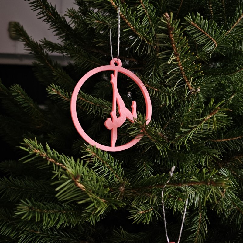 Pink Glow in the Dark Pole Dance Ornament (Pose A) on a blue background. Unique Poledance Christmas Decor