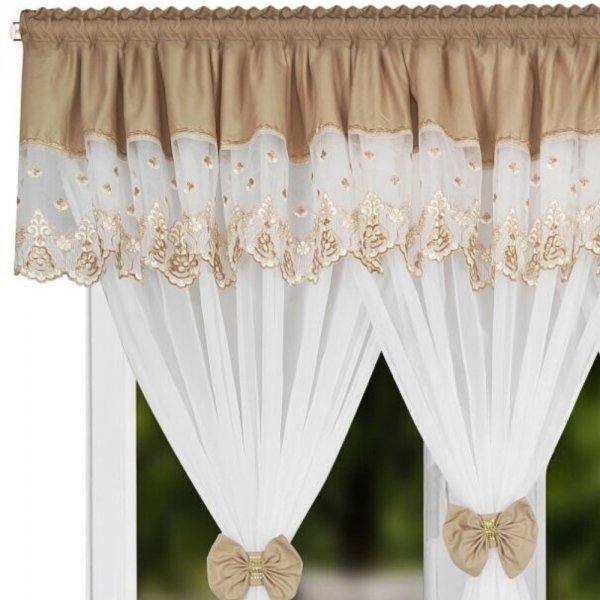 Detal beżowego lambrekinu z haftem i ozdobnym ażurowym wykończeniem dołu.
