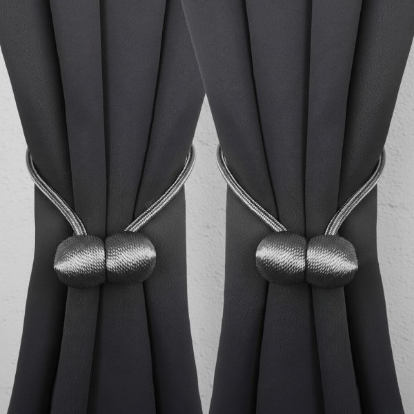 Dwie grafitowe spinki magnetyczne Nelli symetrycznie upinające zasłony – elegancki efekt wykończenia.